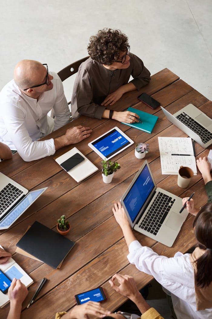 Home High angle view of a diverse team in a modern office setting discussing a business project.