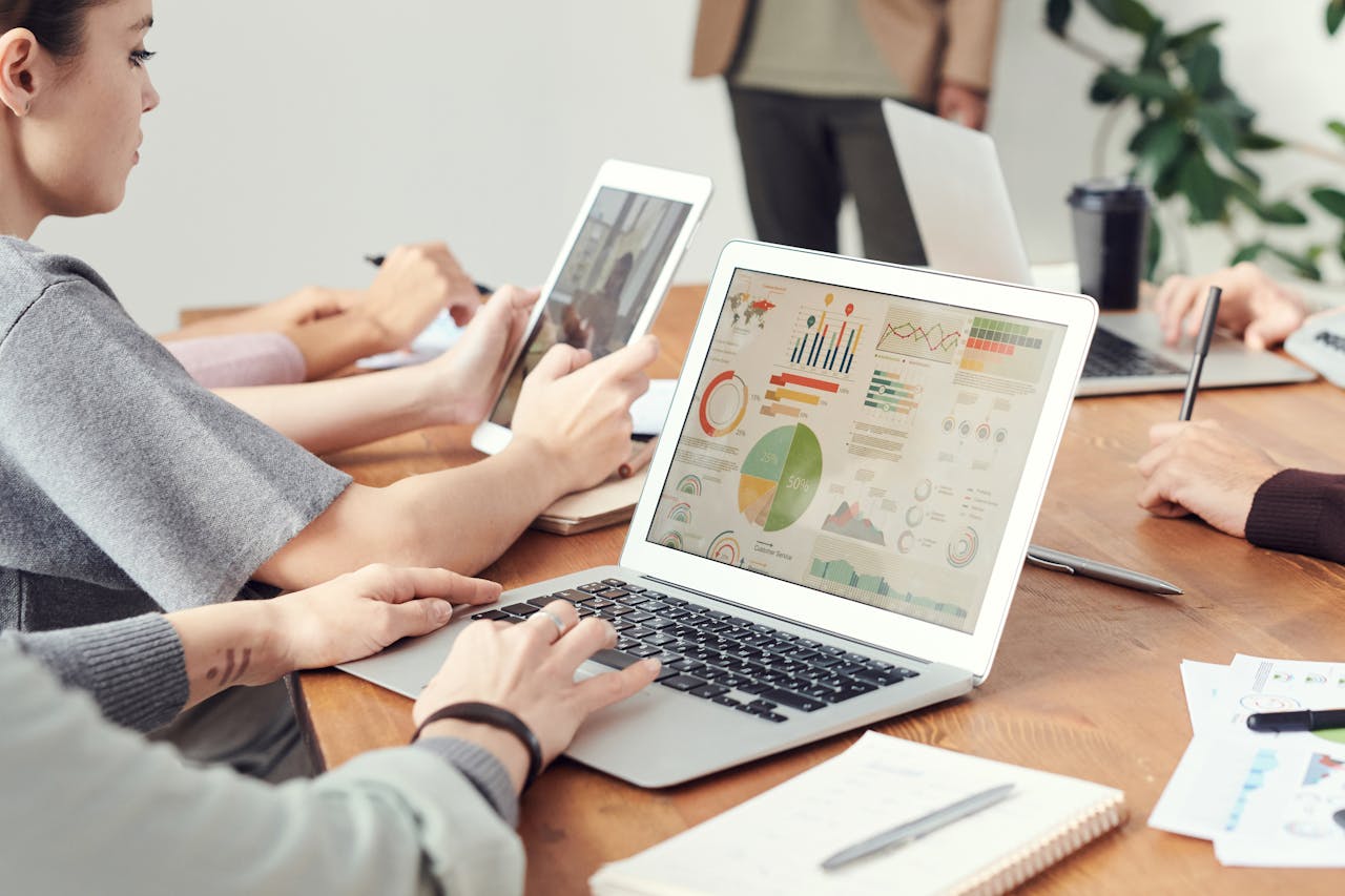 Home Coworkers analyzing data charts on laptops during a team meeting.