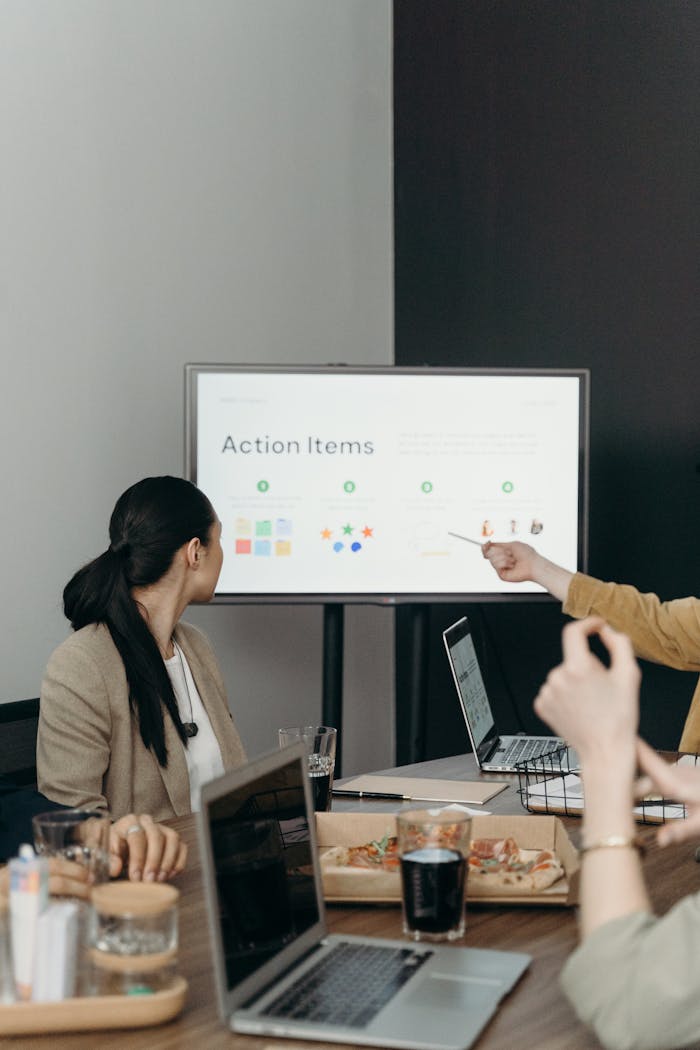 Colleagues discussing a presentation of action items in an office setting.